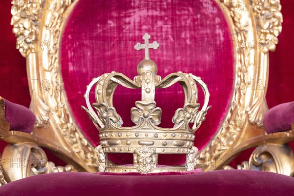 Ancient crown on red velvet. Antique symbol of authority, luxury, monarchy, nobility, success