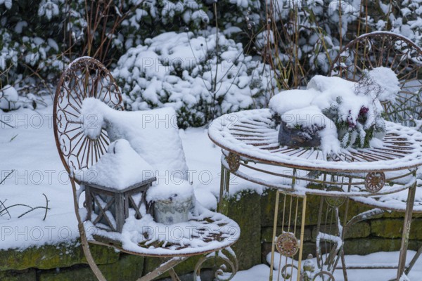 Snow-covered garden table with chairs, decoratively placed in the winter garden, Weseke, borken, Münsterland, North Rhine-Westphalia, Germany, Europe