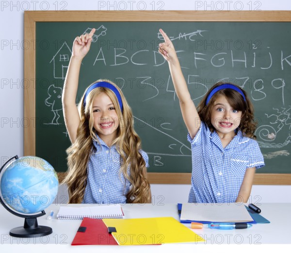 Smart students in classroom raising hand with blackboard