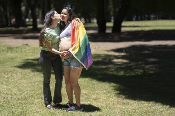 Pregnant latin lesbian couple in a park celebrating LGBT pride
