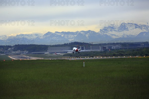 Landing of a Fokker 100 at Zurich Airport. View of the Swiss Alps