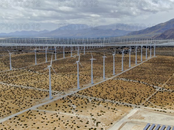 Aerial view of huge array of gigantic wind turbines spreading over the desert in Palm Springs wind farm. California. USA. Aerial view of wind turbines generating electricity