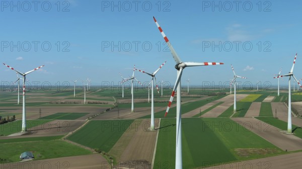 Aerial view of wind turbines and agriculture fields. Windmills turbines generating electricity, green energy