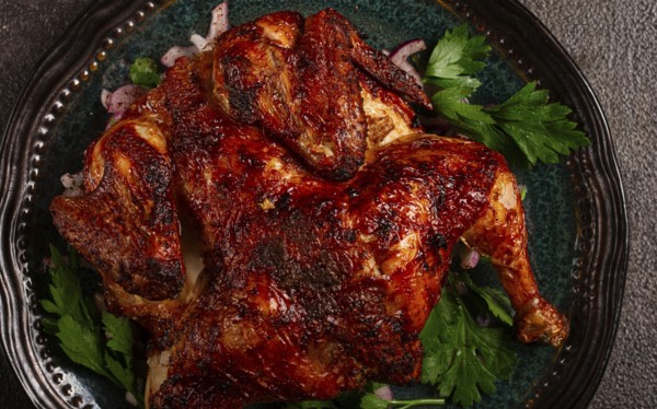 Whole fried chicken, with spices, grilled chicken, on a plate, top view, homemade, no people