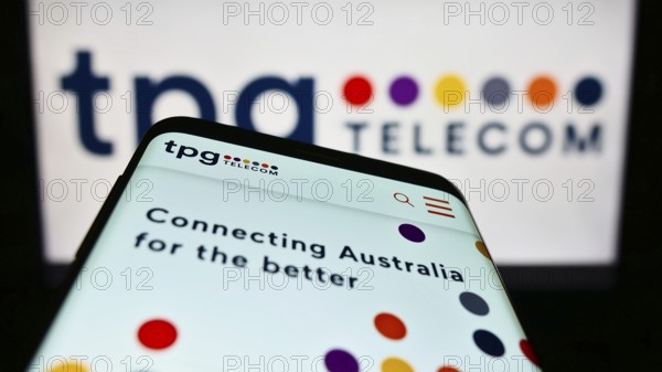 Stuttgart, Germany, 12-30-2022: Mobile phone with website of Australian company TPG Telecom Limited on screen in front of business logo. Focus on top-left of phone display, Europe