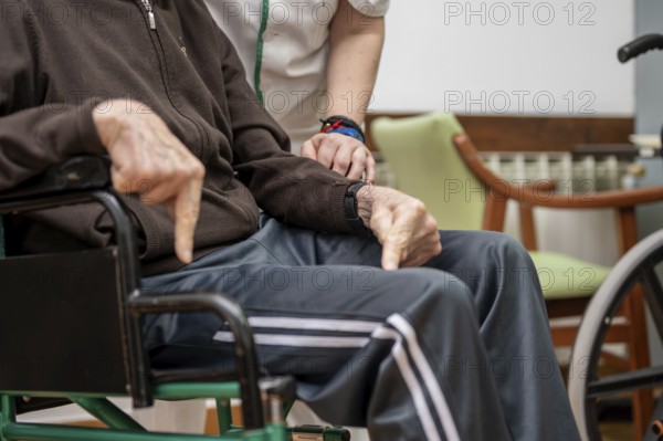 Caregiver assisting elderly man in dining room at nursing home. graphy