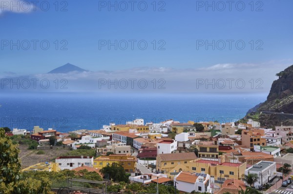 The village of Agulo, behind Tenerife and the Teide in clouds, Agulo, La Gomera, Canary Islands, Spain, Europe