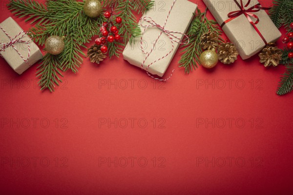 Christmas or New Year celebration red paper festive background with decoration fir tree, wrapped present boxes, cones, berries, sparkly red balls. Space for text, food photography, food photography