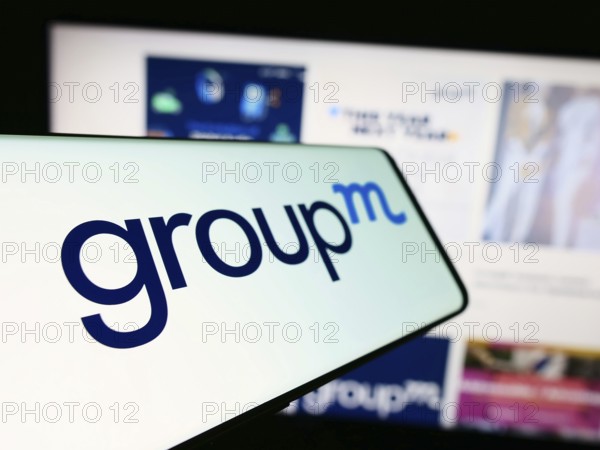 Stuttgart, Germany, 11-03-2023: Cellphone with logo of American media investment company GroupM in front of business website. Focus on left of phone display, Europe