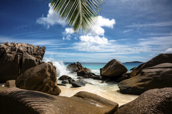 Tropical beach scenery with rocks and palm leaves, sky and sea meet on the horizon, La Digue, Seychelles, Africa