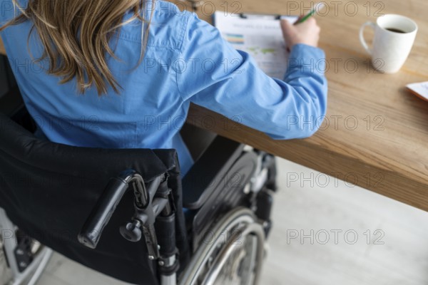 Close up woman wheelchair working office