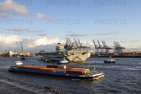 Freighter and aircraft carrier HMS Queen Elizabeth, warship of the British Royal Navy on the river Elbe arriving for a NATO exercise in the harbour of Hamburg, Germany, Europe