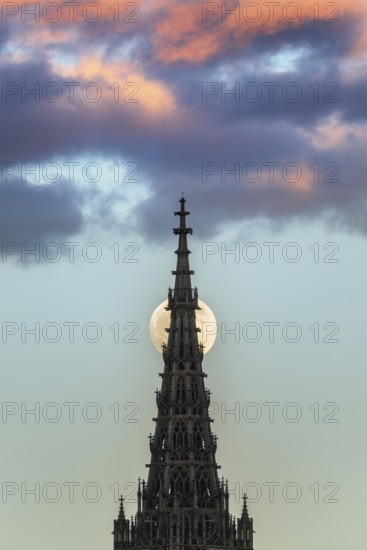 Full moon behind the minster of Ulm at sunset