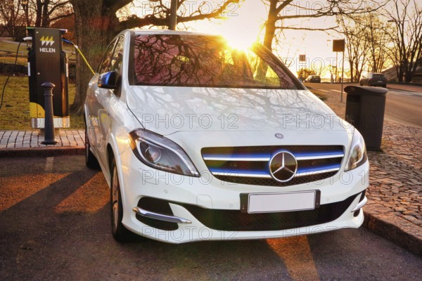 Mercedes-Benz B-Class Electric Drive electric car plugged in at public HELEN charging point. Helsinki, Finland. April 18, 2021