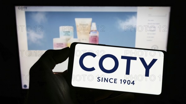 Stuttgart, Germany, 10-03-2022: Person holding cellphone with logo of US beauty company Coty Inc. on screen in front of business webpage. Focus on phone display, Europe