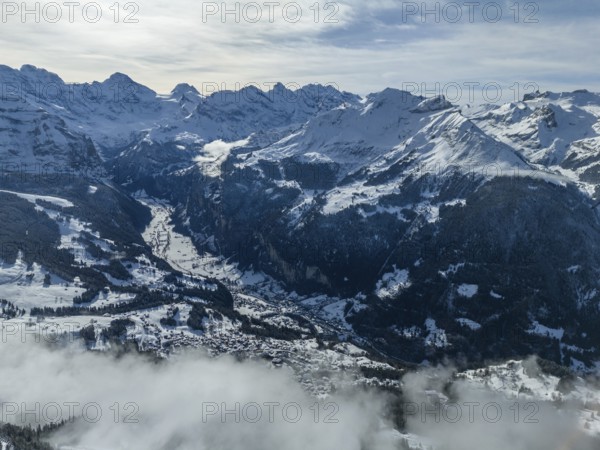 Lauterbrunnen Valley and Snowy Mountains in Winter. Swiss Alps. Switzerland. Aerial View over Clouds. View from Mannlichen Top