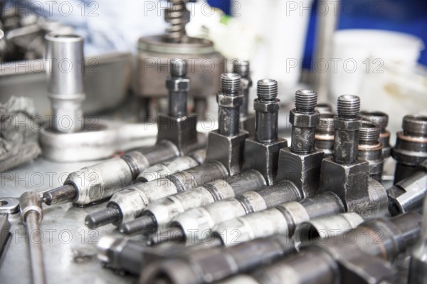 The old diesel injectors lie on the table in the fuel shop. The concept of repair of fuel diesel equipment