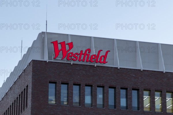 Logo, lettering on the construction site of the Westfield Hamburg-Überseequartier shopping centre, which was severely delayed in its opening date due to construction defects, in the evening light, Hafencity, Hamburg, Germany, Europe