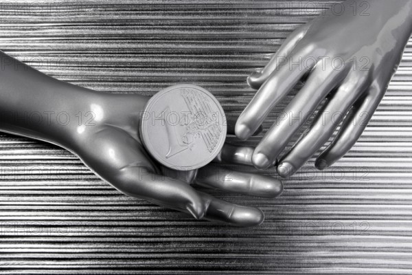 Silver euro coins in futuristic robot gray metallic hands bank metaphor