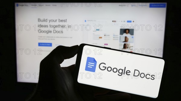 Stuttgart, Germany, 09-23-2023: Person holding mobile phone with logo of online word processing product Google Docs on screen in front of web page. Focus on phone display, Europe
