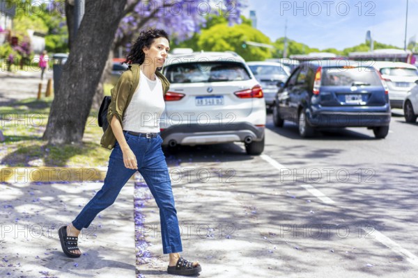 Casual woman looking for a taxi on a busy street