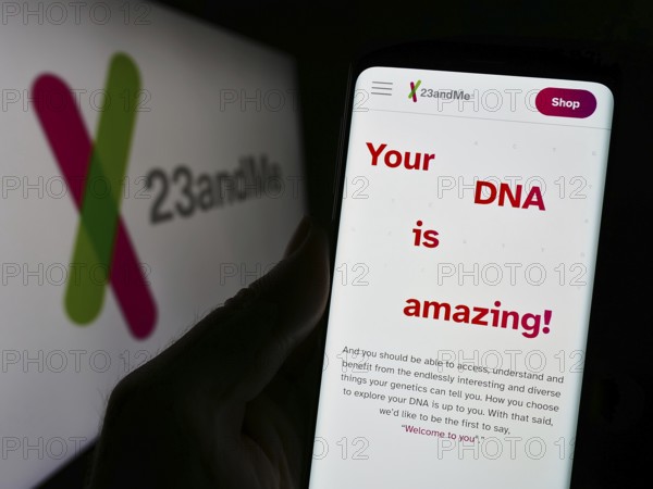 Stuttgart, Germany, 11-03-2023: Person holding cellphone with webpage of US biotechnology company 23andMe Inc. in front of business logo. Focus on center of phone display, Europe