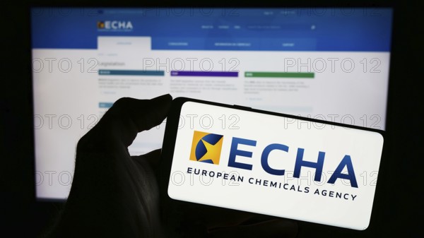 Stuttgart, Germany, 10-20-2023: Person holding cellphone with logo of EU institution European Chemicals Agency (ECHA) in front of webpage. Focus on phone display, Europe
