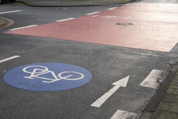 Bike path crossing a red bicycle lane at an urban intersection, promoting cycling infrastructure and road safety