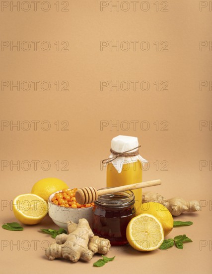 Composition with detox drink, sea buckthorn berries, lemons, mint, ginger, honey in glass jar. Food for immunity stimulation and against flu. Healthy natural remedies to boost immune system, food photography, food photography