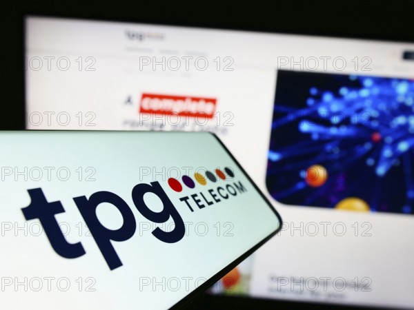 Stuttgart, Germany, 12-30-2022: Cellphone with logo of Australian company TPG Telecom Limited on screen in front of business website. Focus on center of phone display, Europe