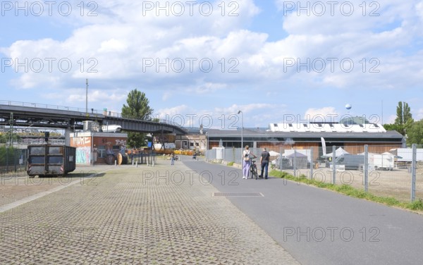 Berlin, Germany, July 14, 2023, summer scene in Park am Gleisdreieck with foot and bike path, elevated railway line and factory buildings, Europe