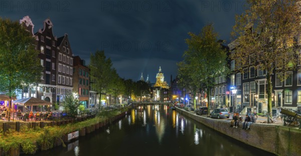 A picture of the Red Light District and the Basilica of Saint Nicholas in the distance, at night, in Amsterdam