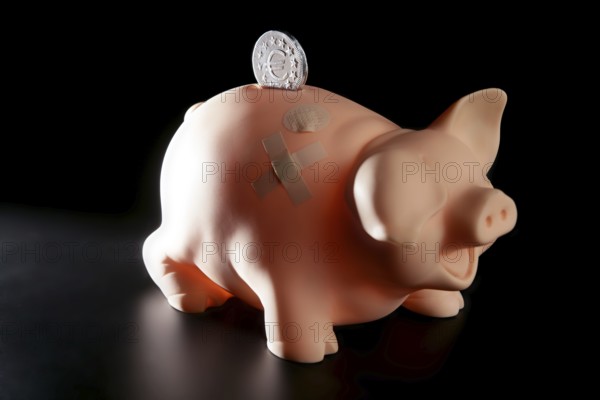 Saving money in crisis time, wounded piggy bank