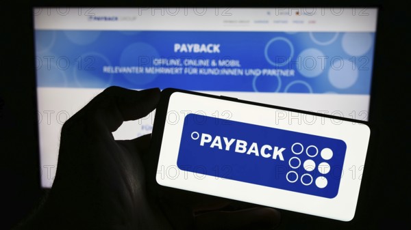 Stuttgart, Germany, 09-01-2023: Person holding cellphone with logo of German loyalty management company Payback GmbH on screen in front of webpage. Focus on phone display, Europe