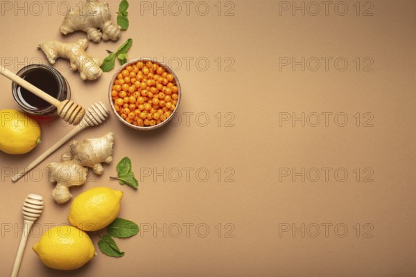 Lemons, mint, ginger, sea buckthorn berries, honey in glass jar, honey wooden dippers top view. Food for immunity stimulation and against flu. Healthy remedies to boost immune system, copy space, food photography, food photography