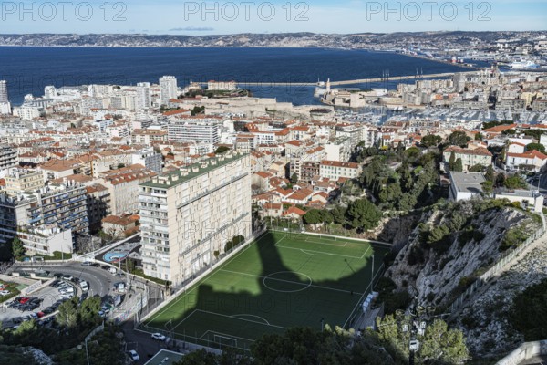 View of football pitch, houses, old harbour and Mediterranean Sea, Marseille, France, Europe