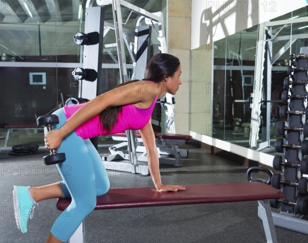 Dumbbell triceps kickback girl workout exercise at gym