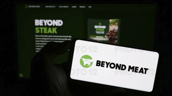 Stuttgart, Germany, 09-11-2023: Person holding mobile phone with logo of American meat substitute company Beyond Meat Inc. on screen in front of web page. Focus on phone display, Europe