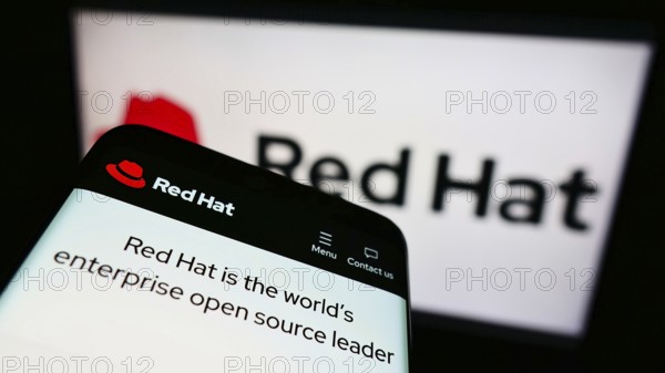 Stuttgart, Germany, 01-06-2022: Mobile phone with webpage of American software company Red Hat Inc. on screen in front of business logo. Focus on top-left of phone display, Europe