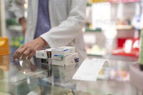 Medications stacked on a pharmacy counter, ready to be sold. Represents a typical scene in the daily routine of a pharmacy