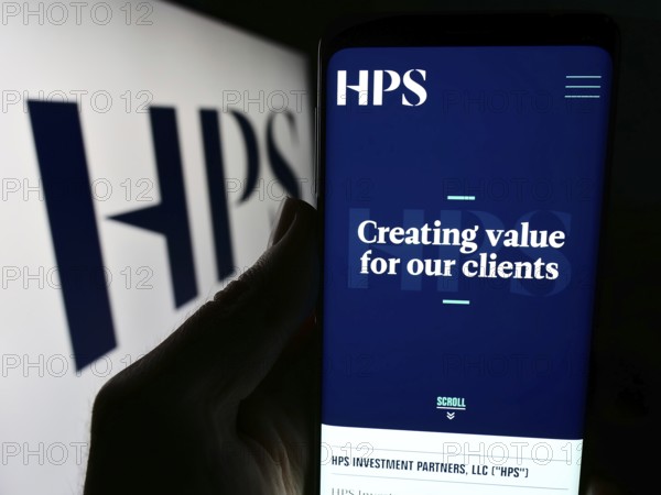 Stuttgart, Germany, 04-13-2024: Person holding mobile phone with website of US company HPS Investment Partners LLC in front of logo. Focus on center of phone display, Europe