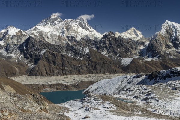 View from Renjo La, the mountain pass in Khumbu, the Everest Region, photographed on a clear, blue sky, autumn day. Mountain panorama consists of eight-thousanders: Mount Everest, Lhotse, Makalu, and other Himalayan peaks including Changtse, Nutptse, Taboche. Ngozumpa, the longest glacier in Himalayas is below. Gokyo settlement sits on its lateral moraine and the Gokyo Lake, Dudh Pokhari shore. Three Passes Trek, post-monsoon trekking season. Sagarmatha National Park, World Heritage Site. Solukhumbu, Nepal, Asia