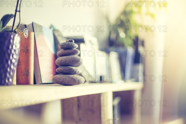 Feng Shui: Stone cairn in the foreground, blurry living room in the background. Balance and relaxation