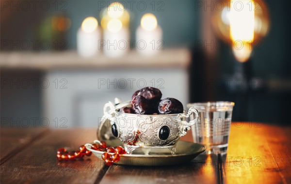 The Muslim feast of the Holy month of Ramadan Kareem. Background with a shining lantern Fanus and dried dates on wooden table. Free space for your text