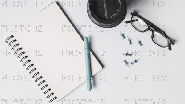 Blank spiral notepad pen coffee cup eyeglasses pushpins white background. Resolution and high quality beautiful photo