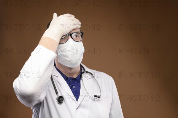 Male Caucasian doctor in white medical uniform shows face palm gesture. Chagrin and disappointment. Copy space