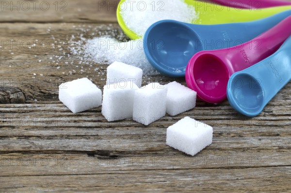 Array of sugar presentations on a wooden table, showcasing sugar cubes and granulated sugar