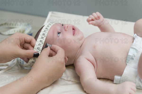 Pediatrician examining little baby in clinic