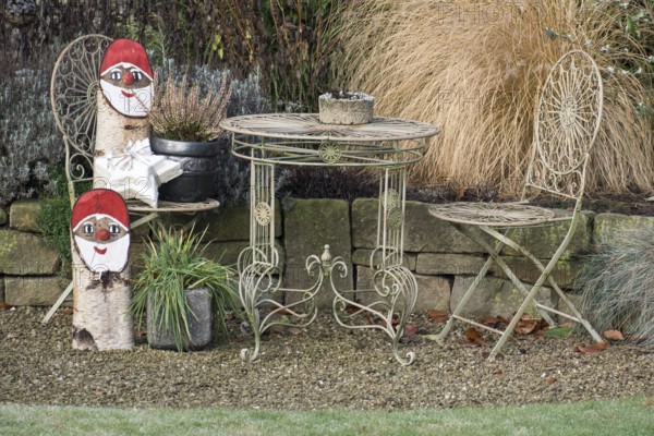 Iron garden furniture and Christmas gnome decorations on a gravel path, borken, North Rhine-Westphalia, germany
