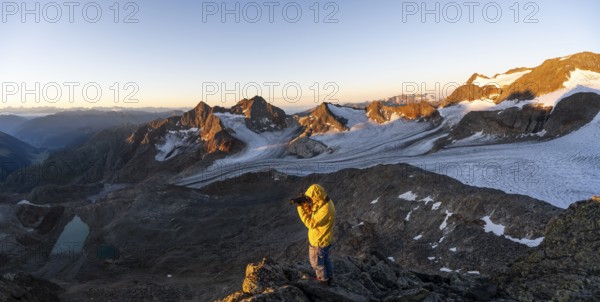 Mountaineers photographed, picturesque high mountain landscape at sunrise with alpenglow, glacier and rocky mountain peaks in the morning light, view at the Becher on mountain peaks Königshofspitz and Sonklarspitze and Schwarzwandspitz with glacier Übeltalferner, Stubai Alps, South Tyrol, Italy, Europe